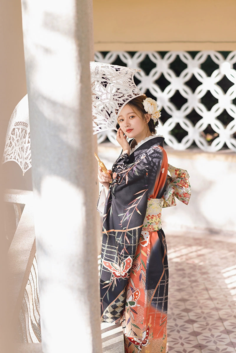 Side view of a black butterfly kimono with floral details, paired with a parasol.