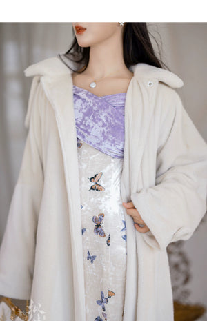 Close-up of a white eco-friendly fur jacket paired with a butterfly-printed fishtail skirt and a purple velvet bodice.