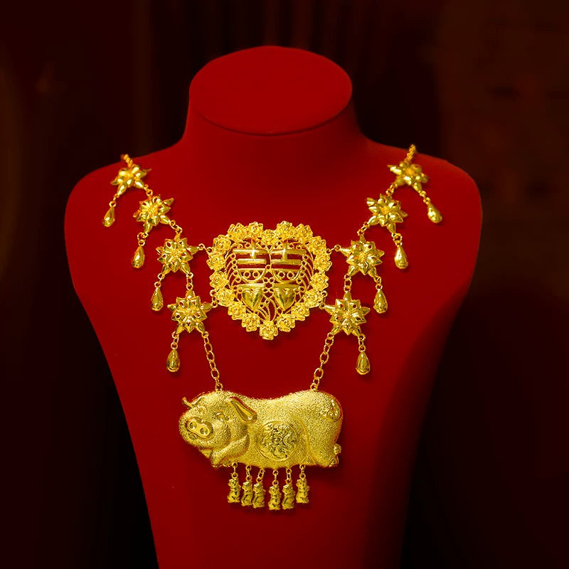 Golden necklace with pig and floral motifs displayed on red stand, matching Chinese wedding headdress accessories.