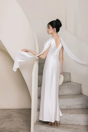 Side view of white hand-beaded evening gown with flowing cape panels