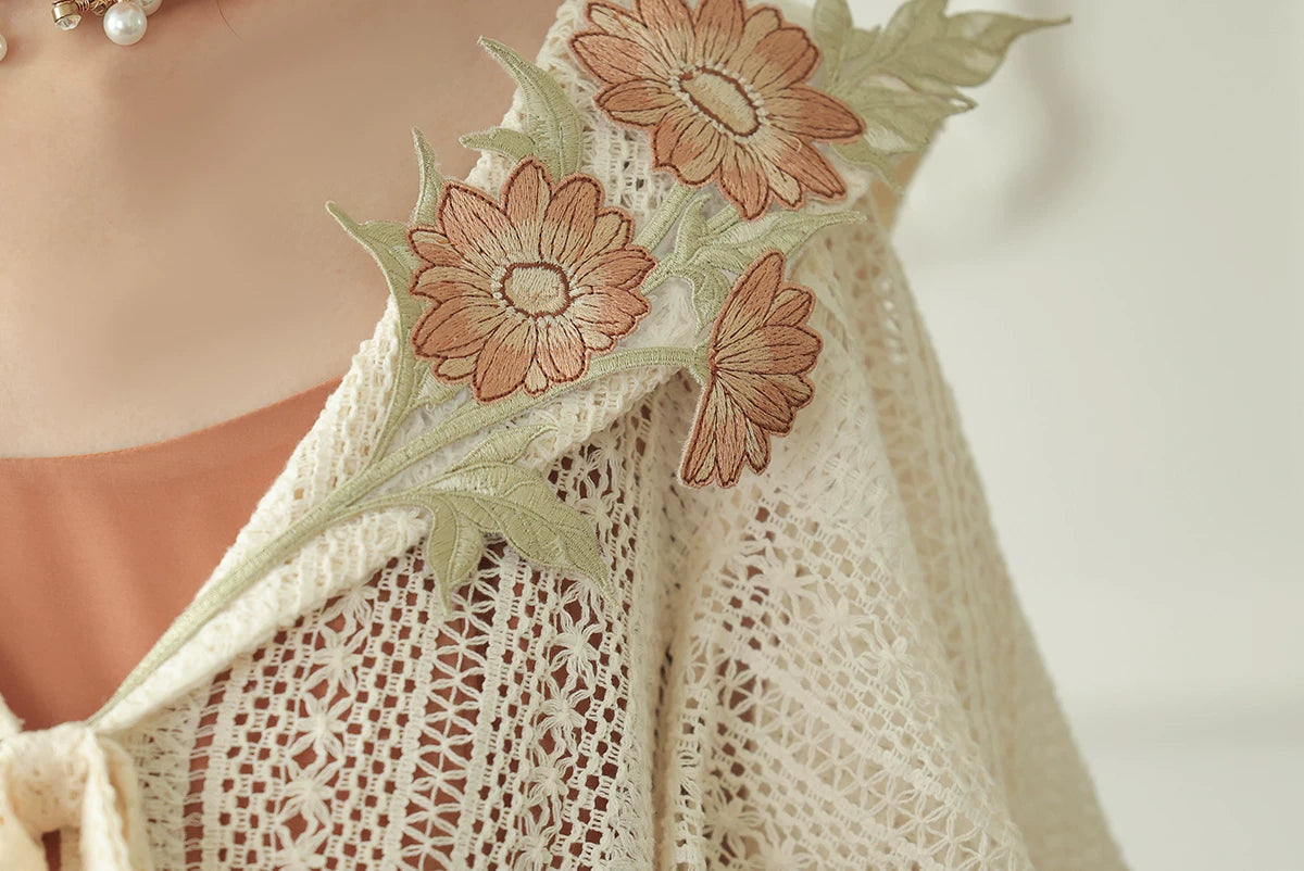 Floral applique detail on the ivory capelet collar