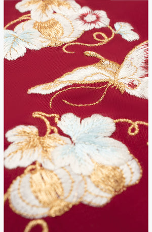 Detailed embroidery of butterflies and flowers on [Dan Que Acacia] New Chinese Style Red Wedding Dress fabric.