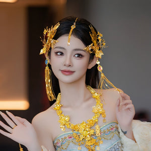 Bride in traditional cheongsam wearing gold Chinese dragonfly hairpin with floral fringe, styled for engagement events.