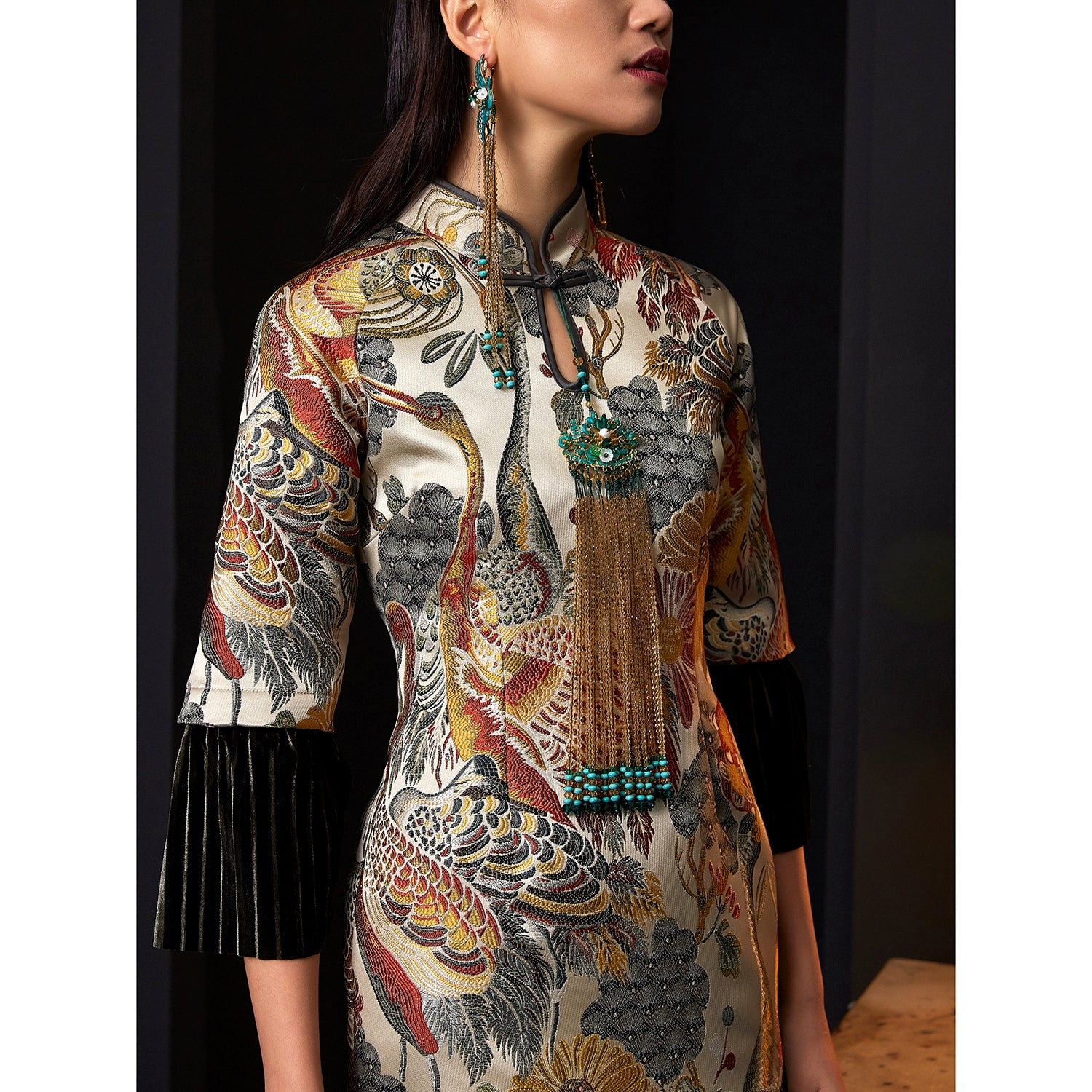 Detailed close-up of jacquard cheongsam dress with velvet sleeve accents.