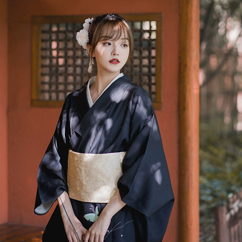 Black vintage yukata kimono with butterfly print, styled with a gold obi belt.