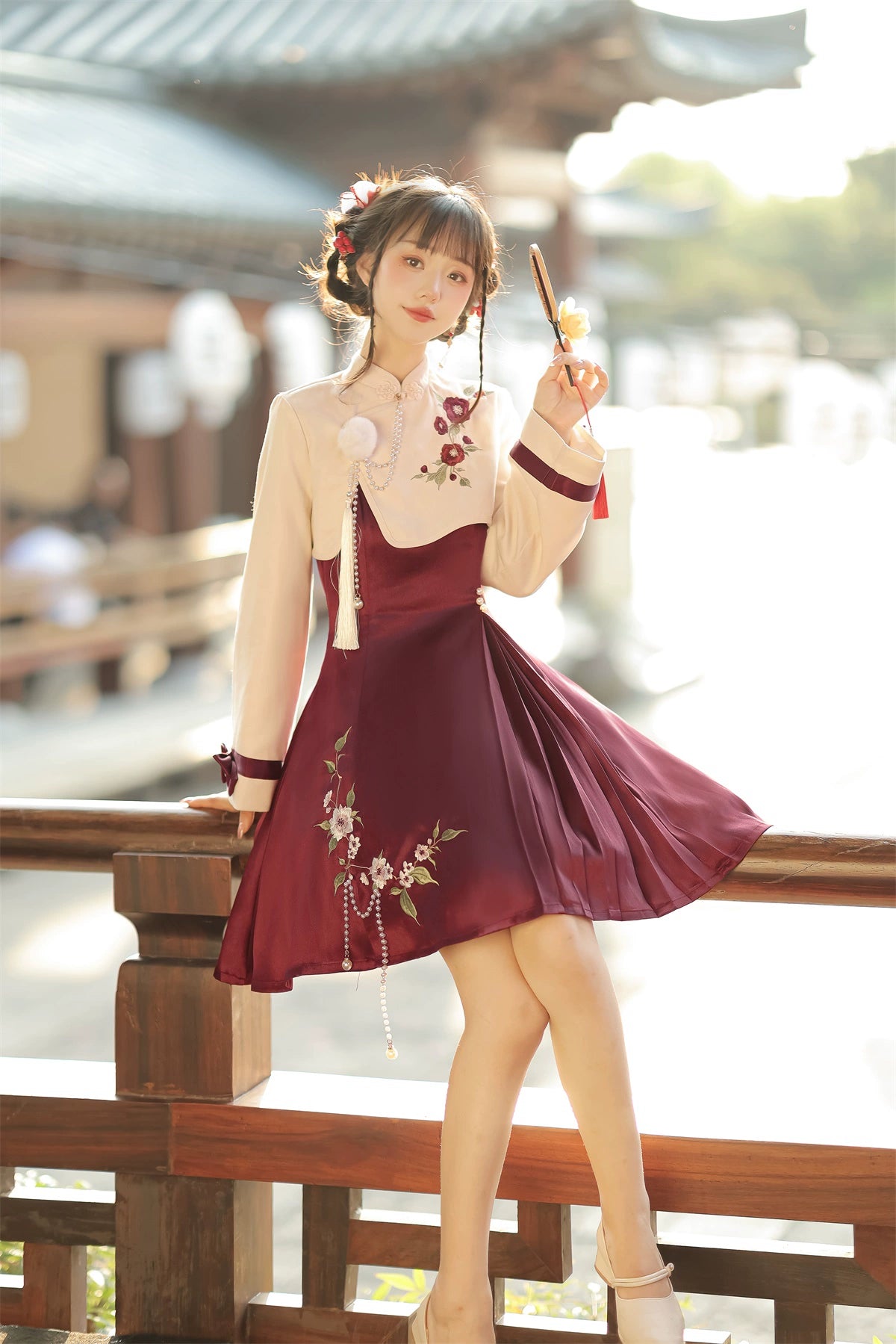 Camellia-inspired Lolita cheongsam dress with cream top, burgundy skirt, floral embroidery, and pearl tassel embellishments.