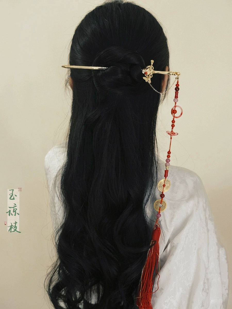 Ancient style shaking tassel hairpin in gold and red, styled in long black hair, ideal for Hanfu or traditional Chinese attire.