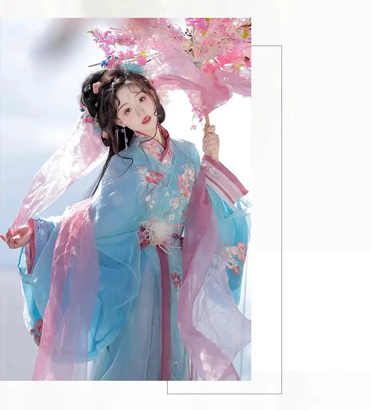 Woman in blue Hanfu holding pink floral umbrella