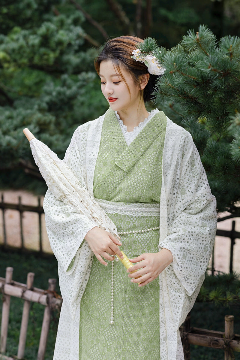 Model smiling in green Taisho Roman kimono with lace parasol.