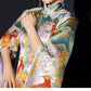 Detailed view of white phoenix cheongsam showcasing vibrant floral jacquard fabric.