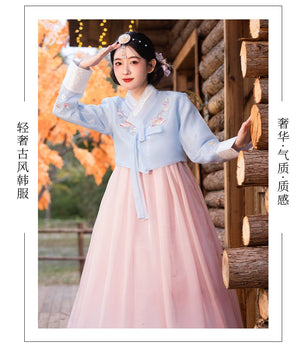 Luxurious traditional Korean hanbok in soft blue and pink hues, adorned with intricate floral embroidery.