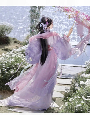 Back view of woman in purple Hanfu with floral umbrella