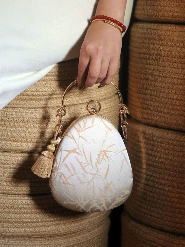Light apricot bamboo-pattern teardrop bag carried by its handle