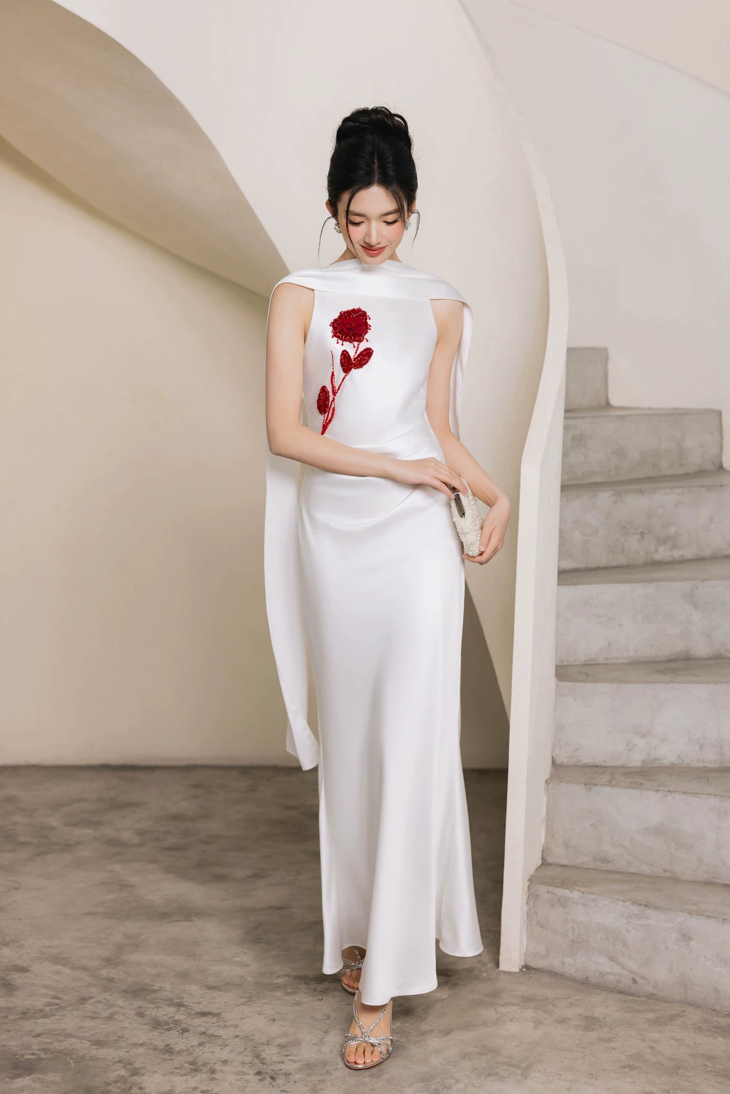 White hand-beaded evening gown with red floral motif, full front view