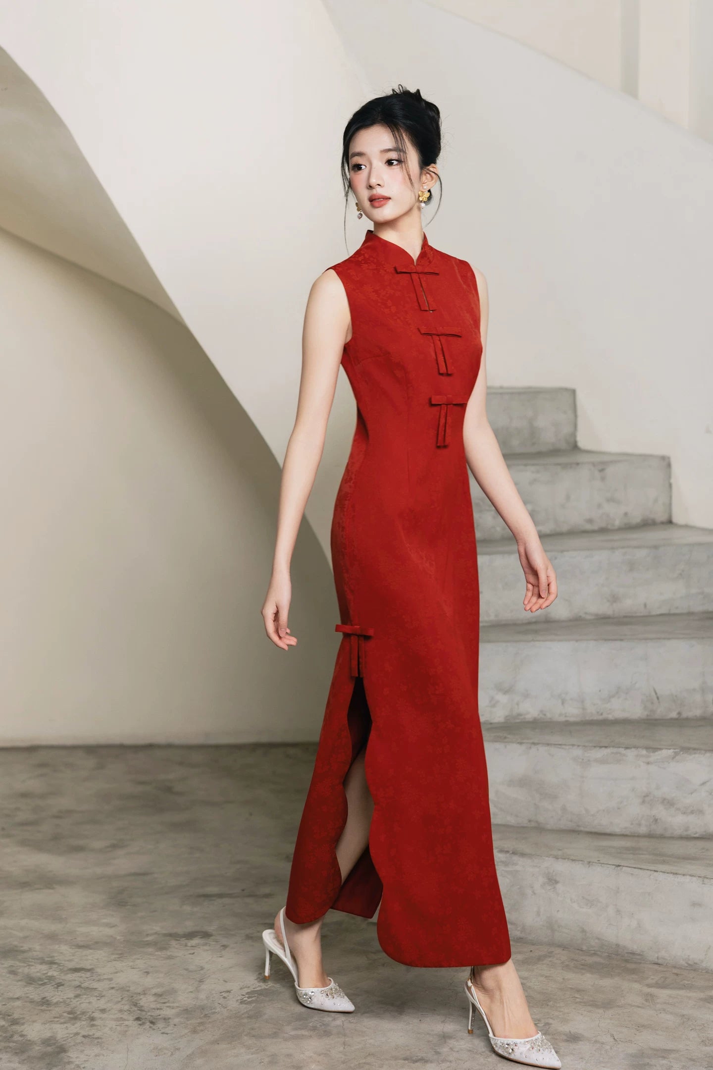 Vermilion red sleeveless cheongsam in walking pose by staircase
