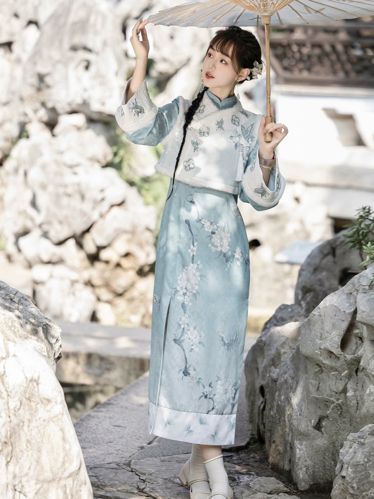 Modernized traditional cheongsam dress with a soft blue hue and embroidered details. A sophisticated choice for autumn and winter fashion.