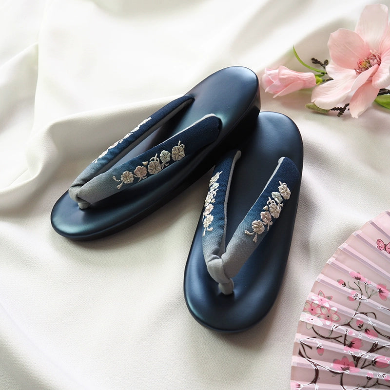 Navy blue Japanese kimono slippers with intricate floral embroidery and gradient herringbone straps. Ideal for formal wear and cosplay accessories.