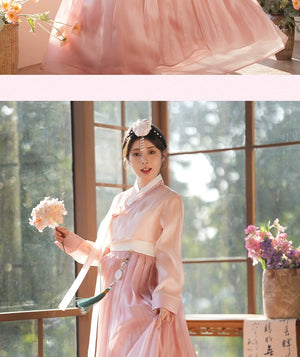 Soft pink hanbok dress with a delicate floral hairpiece. A stunning outfit for weddings, festivals, and traditional ceremonies.