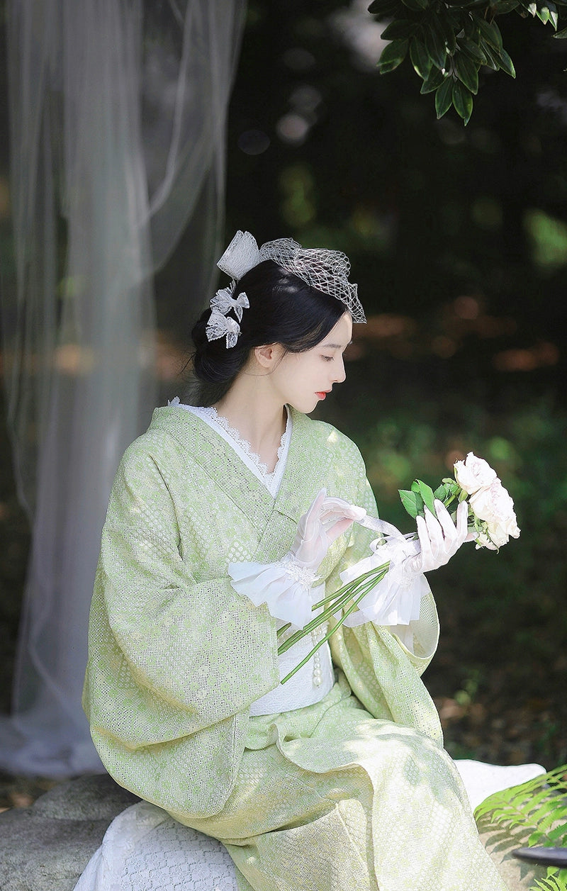 Elegant green kimono dress with lace gloves and floral bouquet.