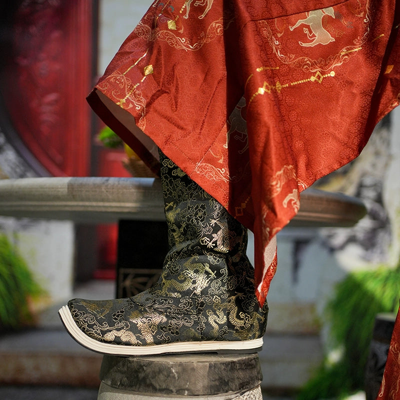 Traditional Dragon boots with intricate gold embroidery on black fabric, styled with a red Hanfu robe, perfect for cultural enthusiasts.