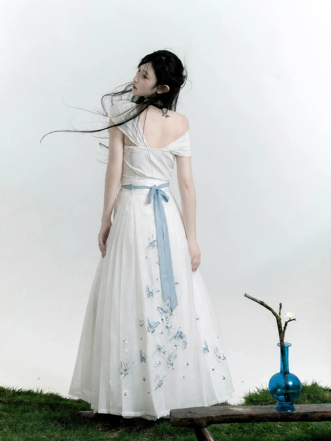Back view of the white butterfly Hanfu separates showing a blue waist tie and embroidery on the skirt panel