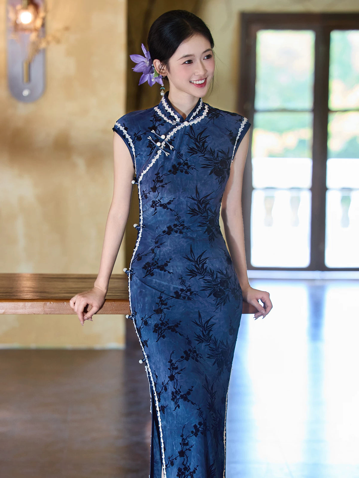 Blue bamboo-pattern sleeveless qipao with pale trim around the stand collar and diagonal front