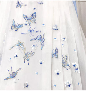 Blue butterflies and small floral embroidery scattered across the sheer white mamian skirt fabric