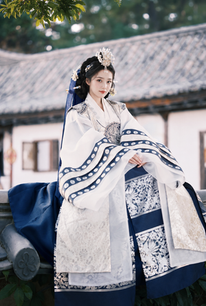 Seated front view showing navy skirt with silver ornamental bands