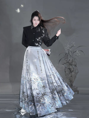 Sky blue floral and calligraphy mamian skirt paired with a black blouse in a standing pose.