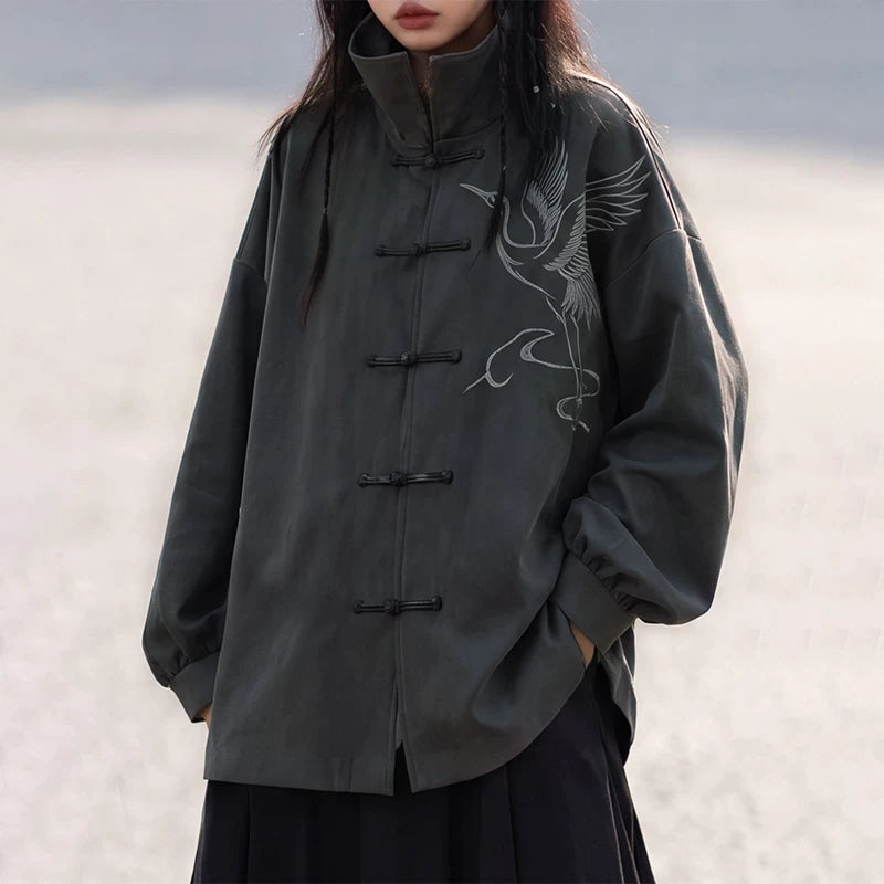Close-up of crane embroidery and frog closures on the charcoal jacket