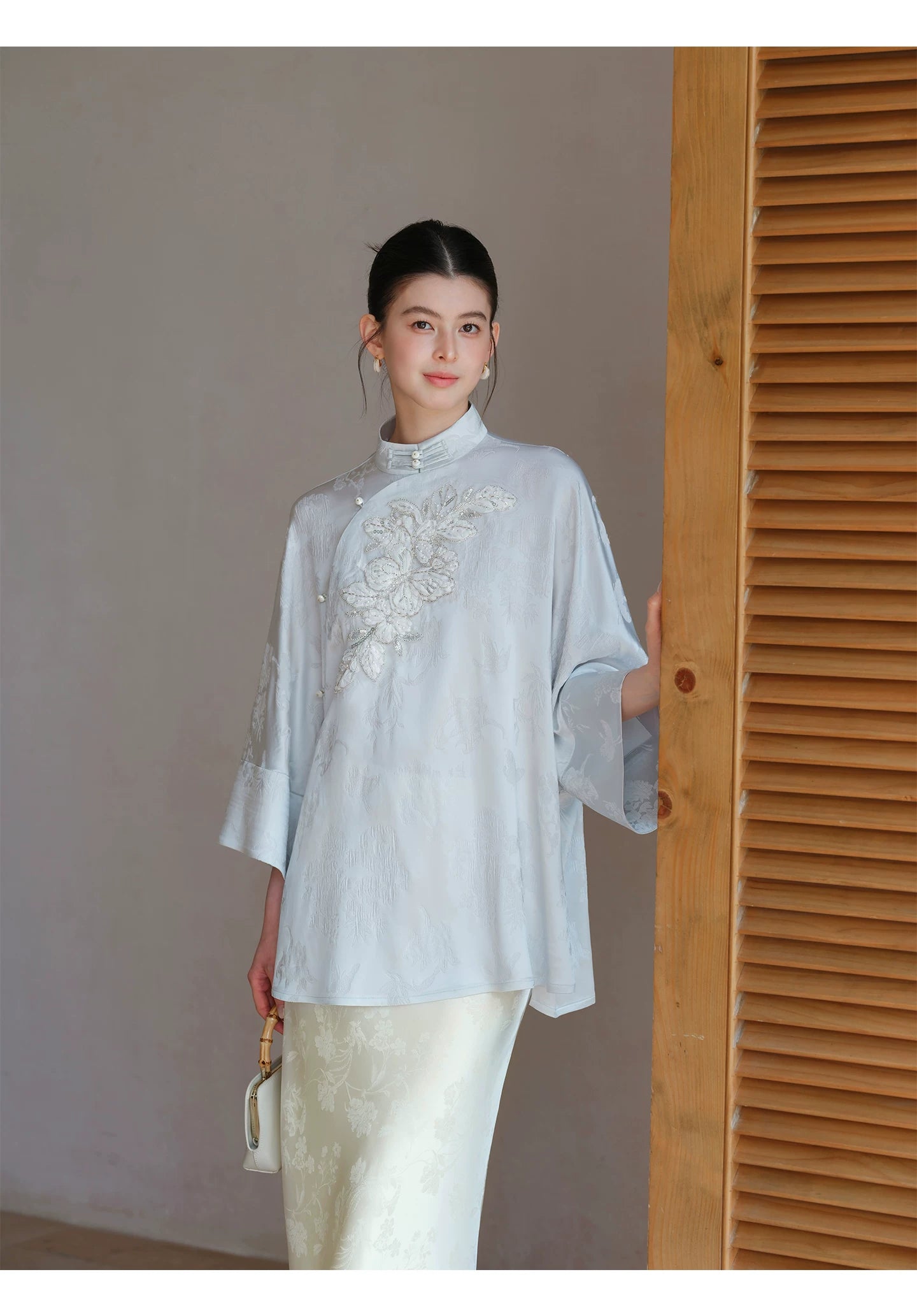 Cloud-Mist Blue embroidered satin top and skirt shown as a polished New Chinese Style outfit, highlighting floral bead embroidery, stand collar and fluid satin silhouette.