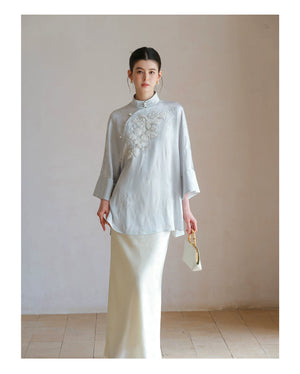 Cloud-Mist Blue embroidered satin top and skirt styled to show its fit and drape, including floral bead embroidery, stand collar and fluid satin silhouette.