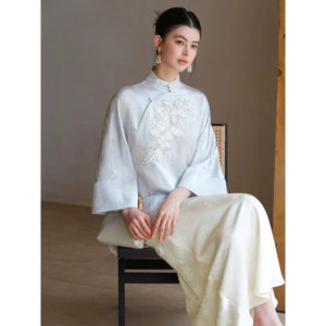 Close product view of the Cloud-Mist Blue embroidered satin top and skirt, focused on its Chinese-inspired design details.