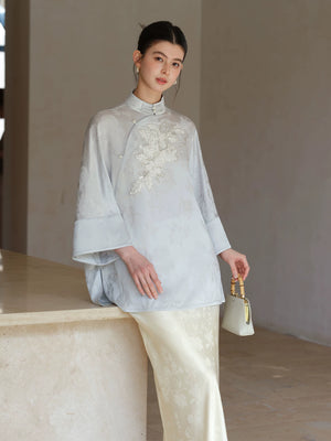 Front styling view of the Cloud-Mist Blue embroidered satin top and skirt, with floral bead embroidery, stand collar and fluid satin silhouette.