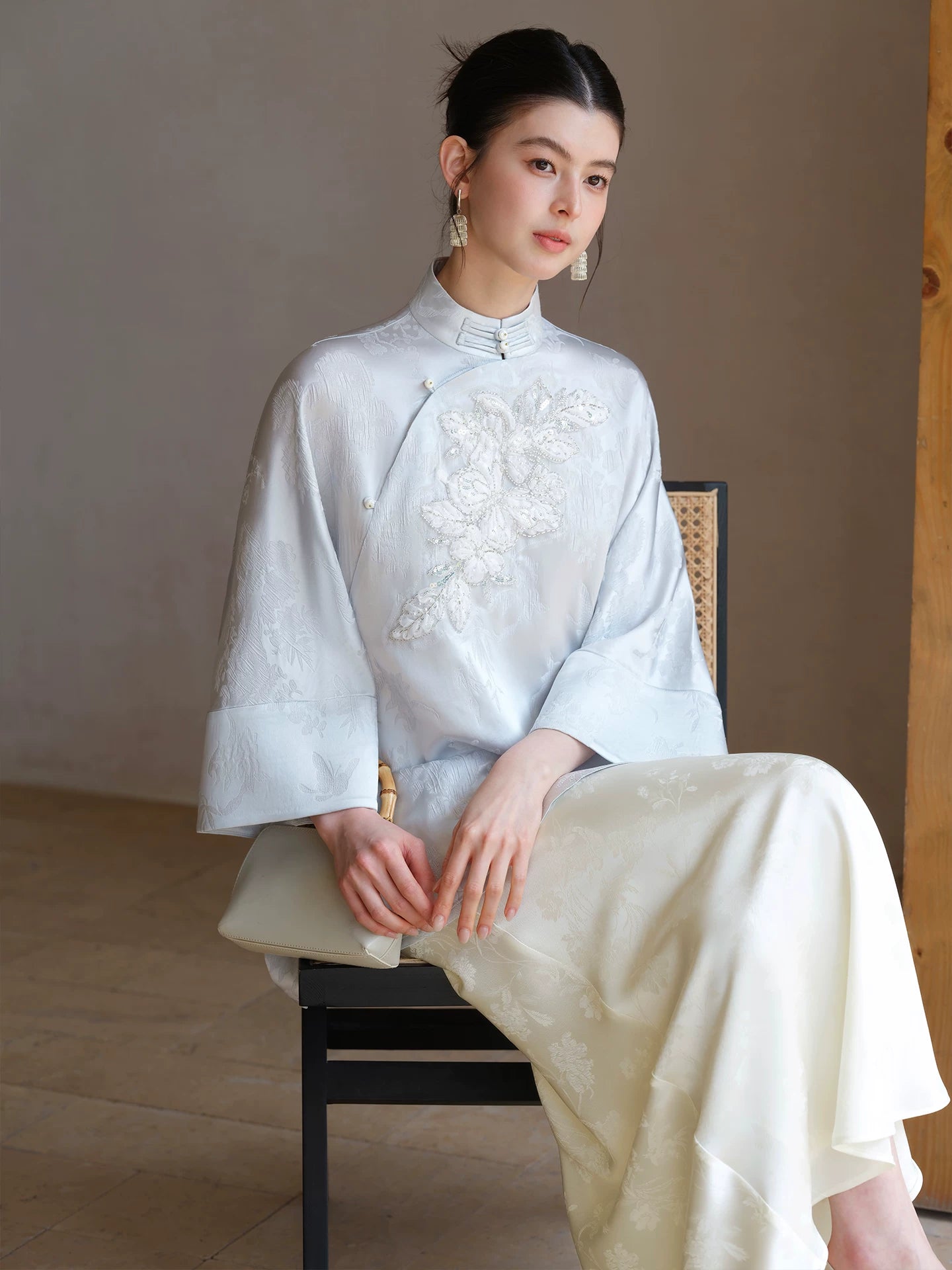 Three-quarter product view of the Cloud-Mist Blue embroidered satin top and skirt, a refined New Chinese Style outfit for elegant occasions.