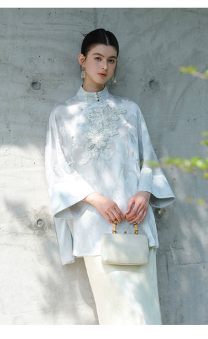 Cloud-Mist Blue embroidered satin top and skirt styled to show its fit and drape, including floral bead embroidery, stand collar and fluid satin silhouette.