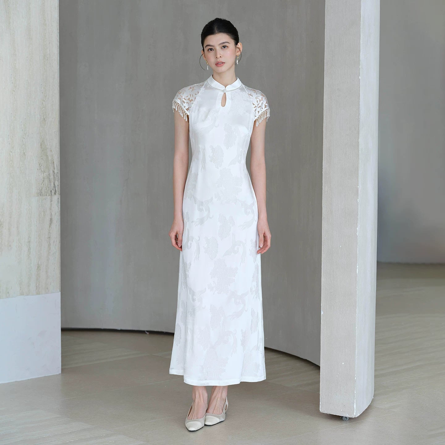 Detailed product image of the Crane White cutwork tassel qipao dress, showing fabric texture, finish and craftsmanship.