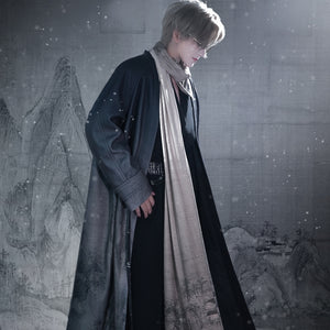 Person in a long coat and scarf standing in a snowy landscape with a mural in the background