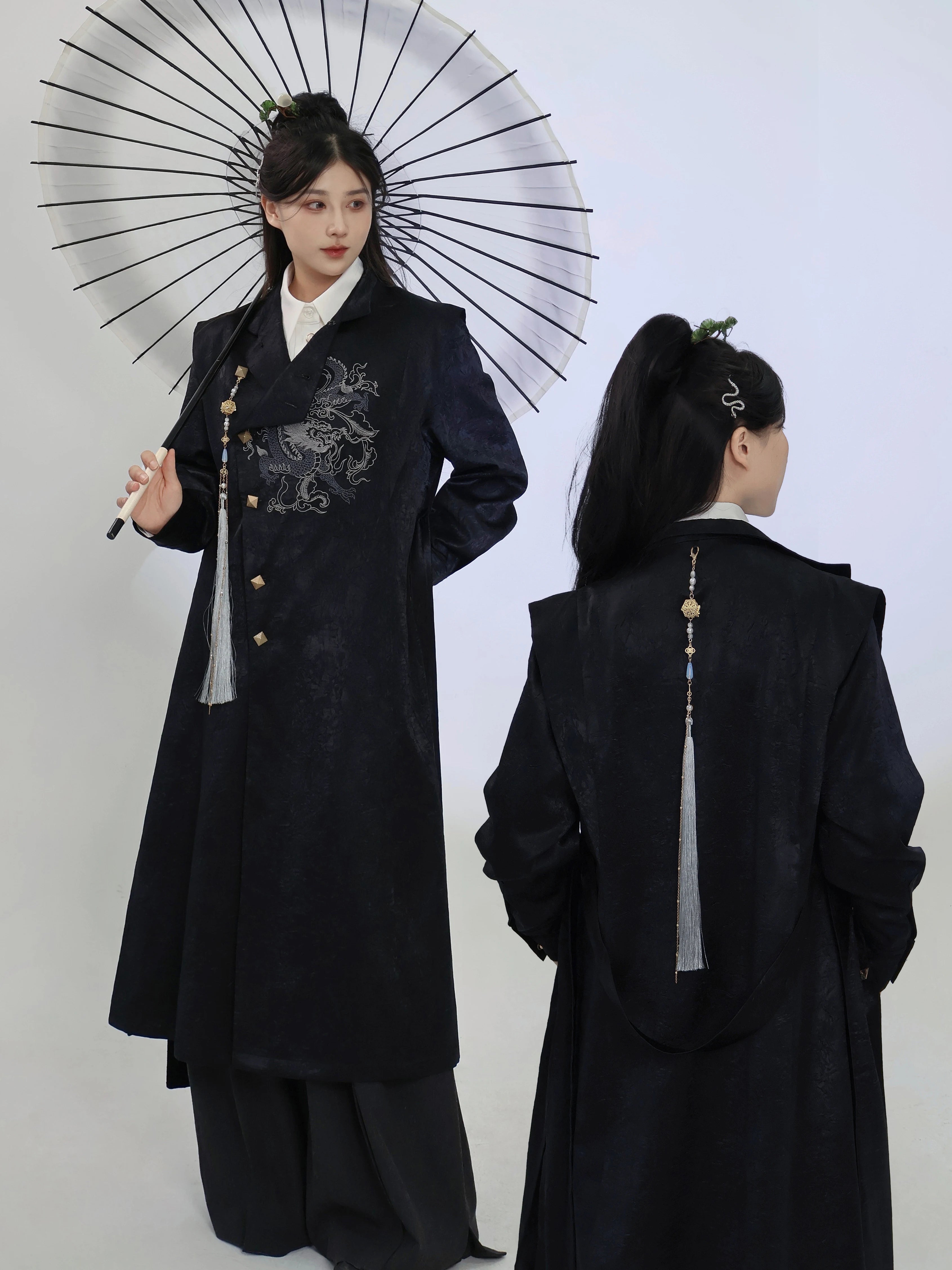 Black dragon embroidery long coat shown from the front and back, with an asymmetric button front and a long decorative tassel for unisex New Chinese style.