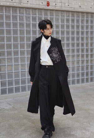 Black long coat with dragon embroidery worn open on a male model over a white shirt and black trousers for a contemporary Chinese style outfit.