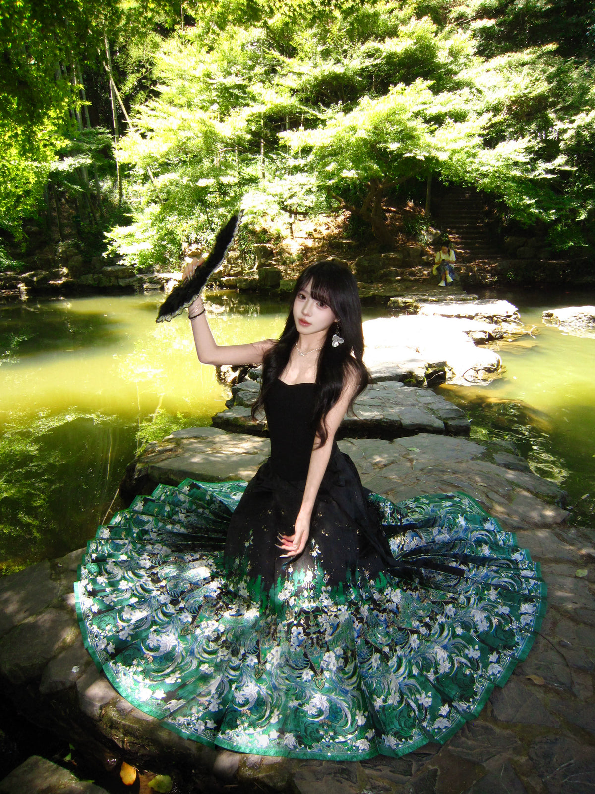 Green brocade mamian skirt with pleats spread in a garden