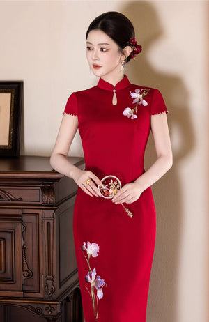 Iris Red Bridal Cheongsam — Three-quarter view holding a round floral accessory