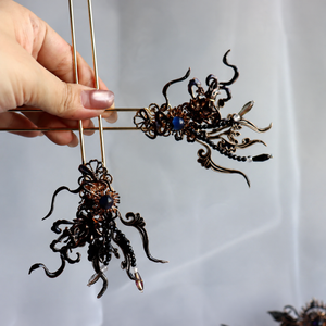 Pair of dark decorative side hairpins, close-up