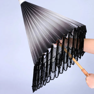 Ink-gradient parasol with dark tassels and decorative canopy detail