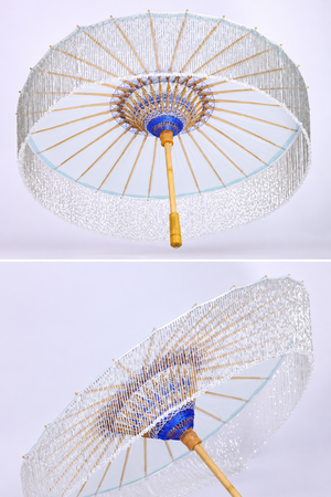 Ice-blue oil-paper parasol shown open from below with bamboo ribs and woven hub details