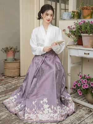 Purple magnolia mamian skirt with a white cross-collar blouse, seated outdoor styling