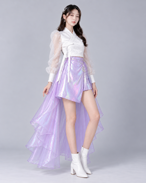 Three-quarter view of the iridescent lavender mini skirt, white wrap-style top and detachable layered back skirt.