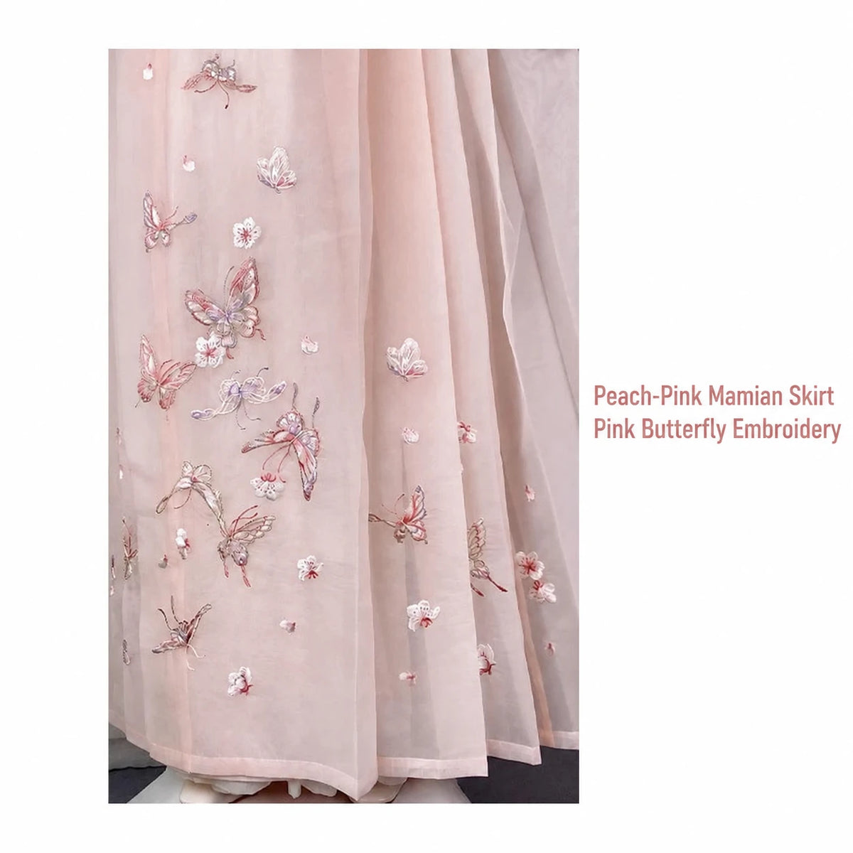 Peach-pink mamian skirt close-up with pink butterflies and small floral embroidery
