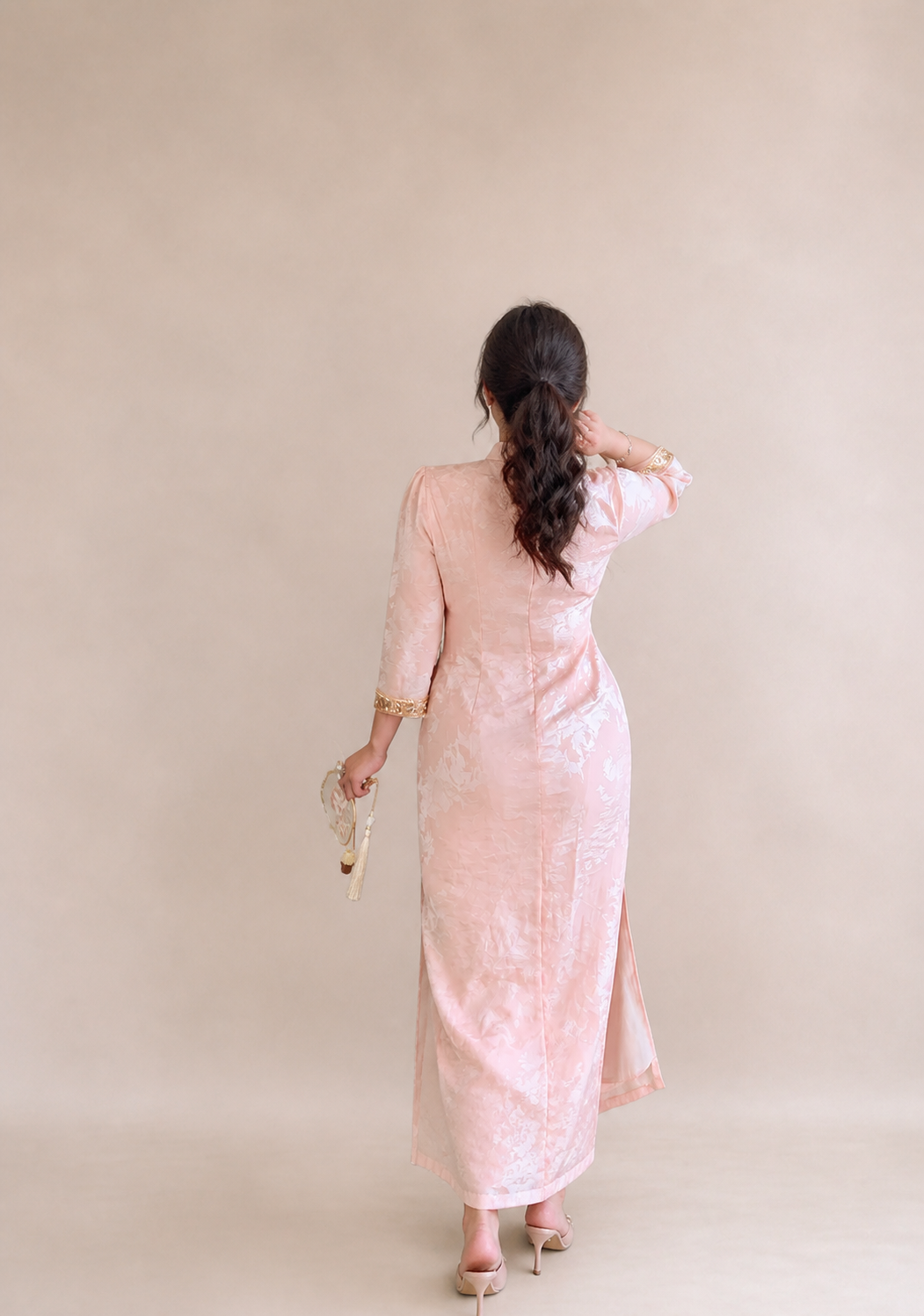 Back view of the pearl blush jacquard plus size qipao dress showing its fitted silhouette and side slit