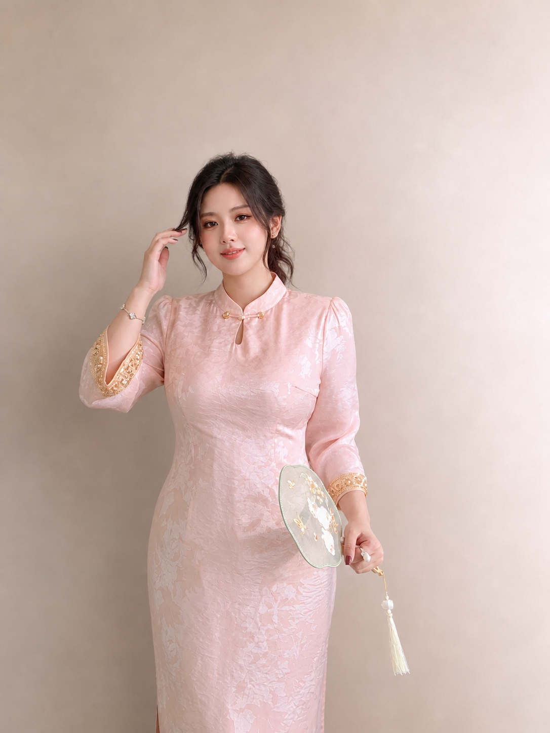 Pearl blush plus size cheongsam showing the mandarin collar, gold closures and jacquard texture